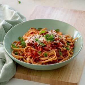 a bowl of finished pasta topped with cheese and herbs.