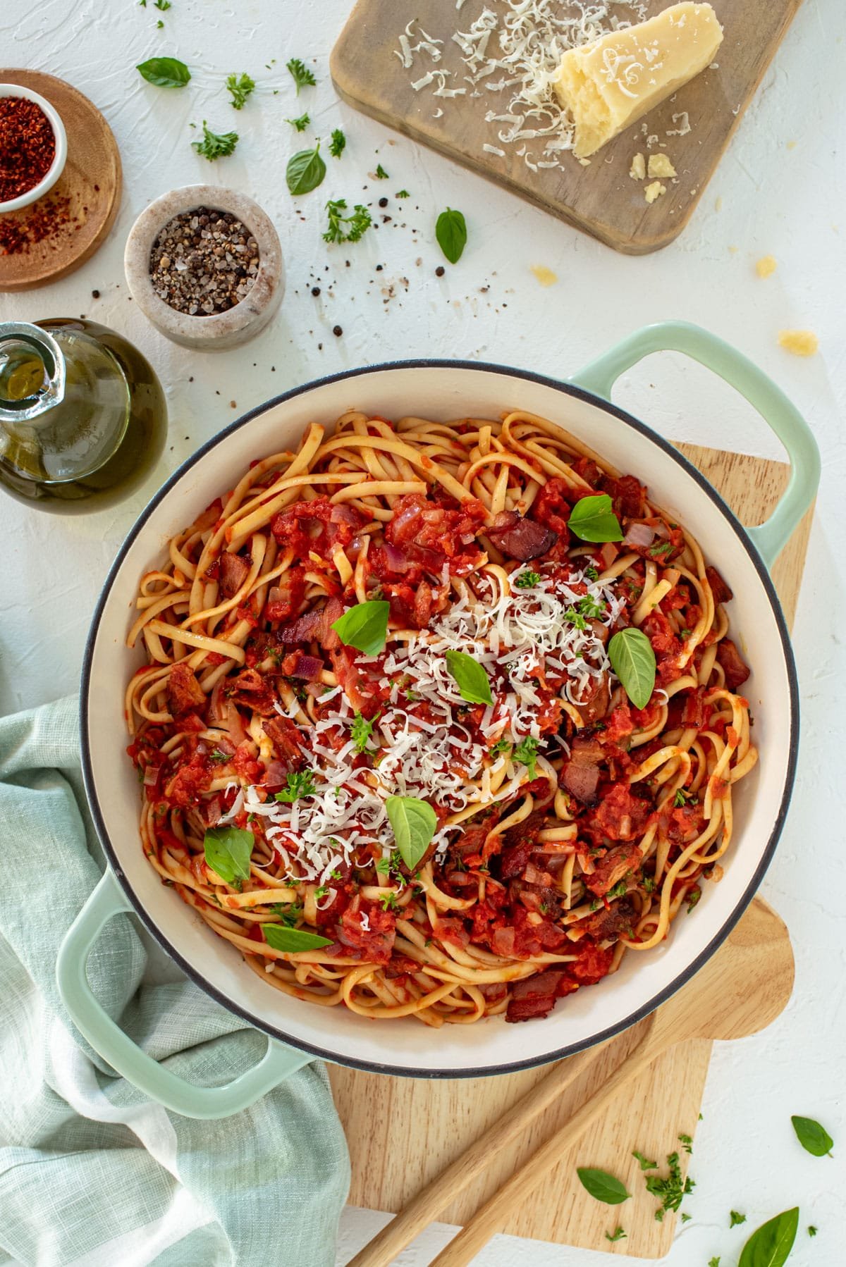 a pot of pasta topped with tomato sauce, bacon and cheese.