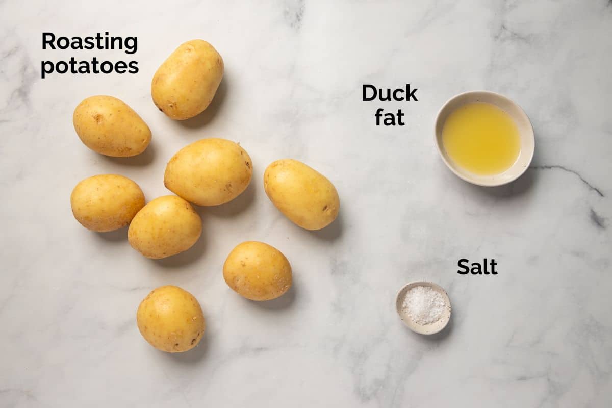 all ingredients for duck fat roast potatoes, laid out on a table.