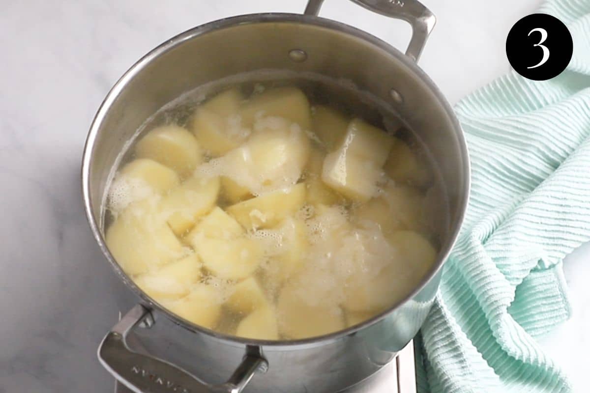 potatoes par-boiling in a pot of water.
