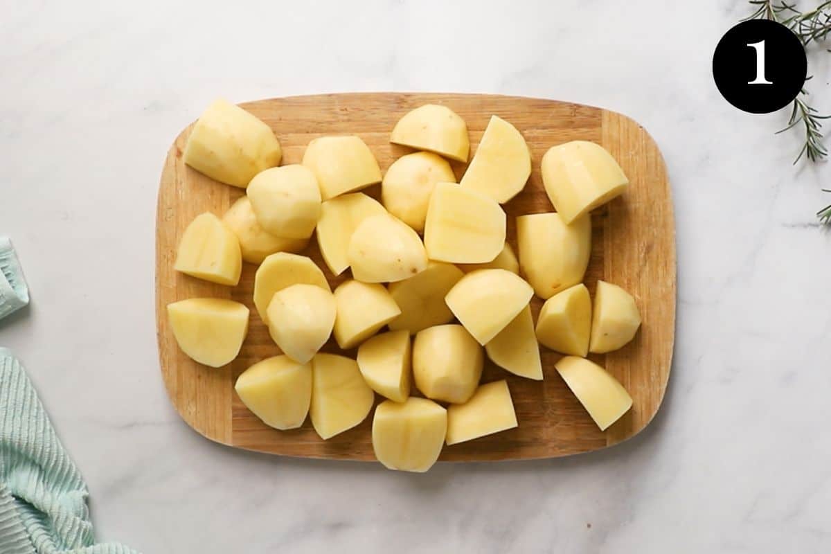 chopped and peeled potato pieces on a wooden board.