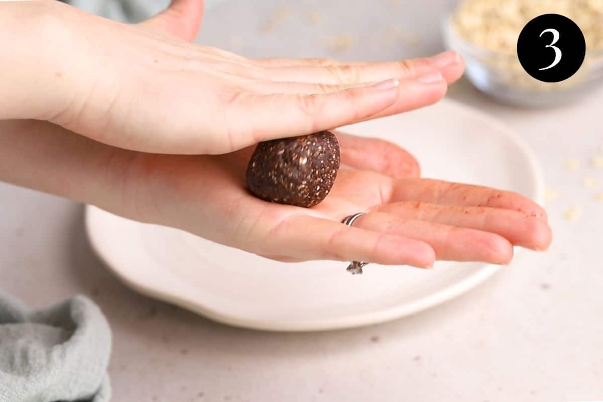 hands rolling chocolate mixture into a ball.