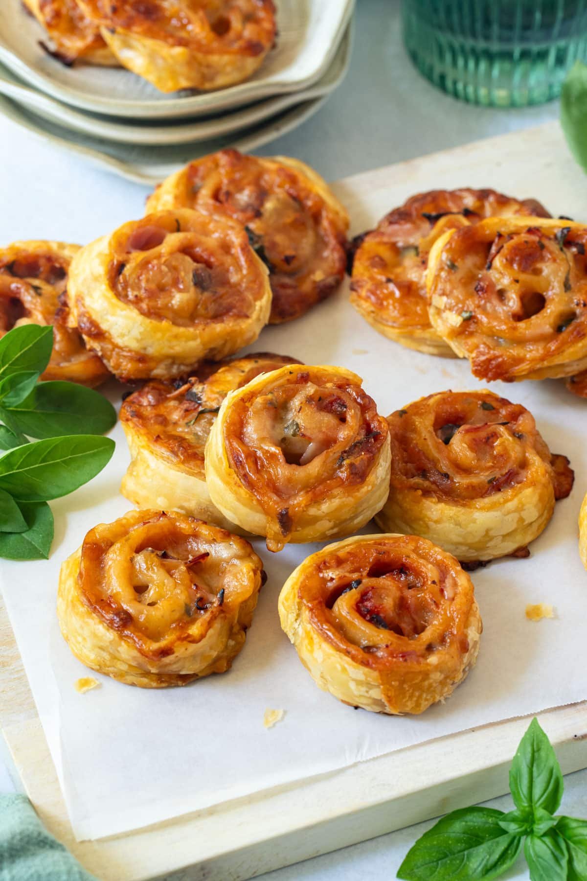 pizza pinwheels on a wooden board, with basil.