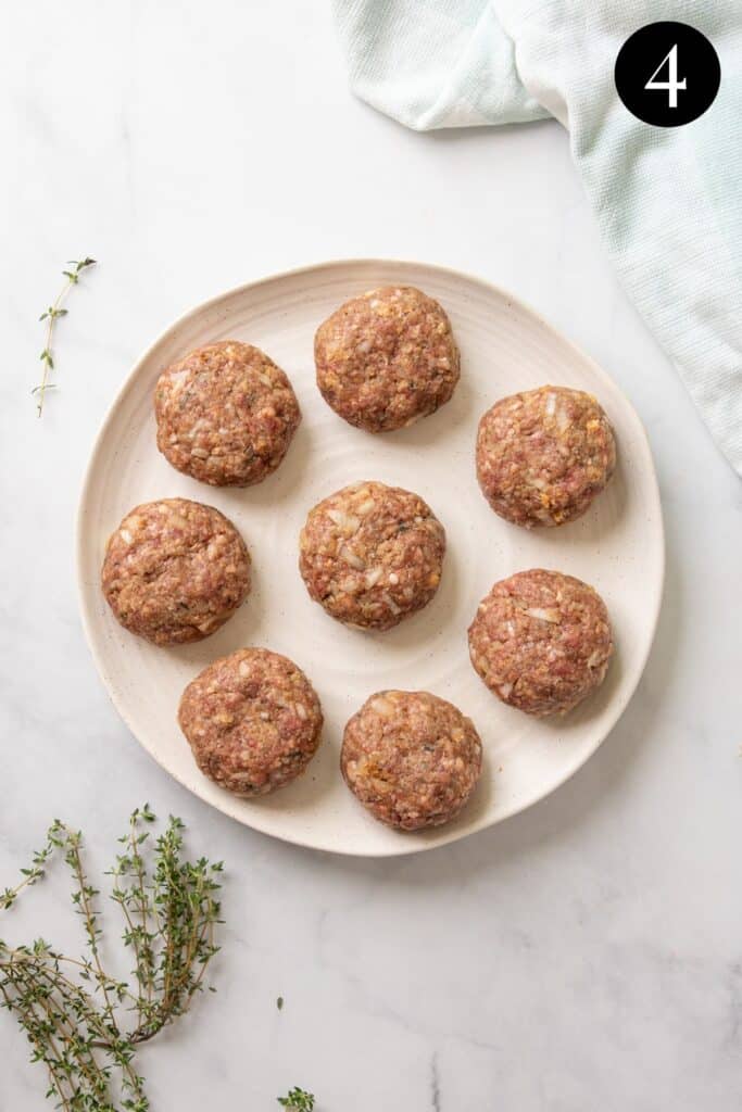 uncooked rissole patties arranged on a plate.