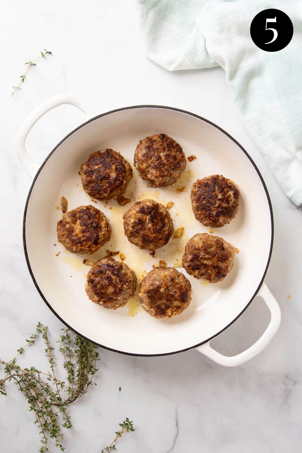 finished rissoles in a white pan.