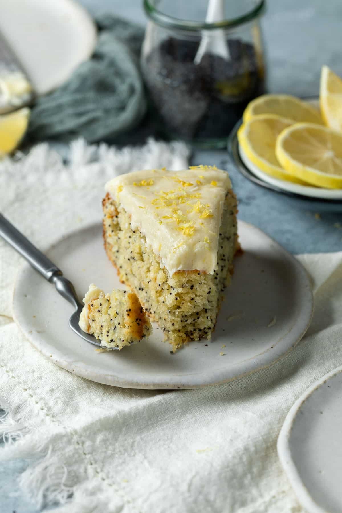 a slice of finished cake with a fork and slices of lemon.