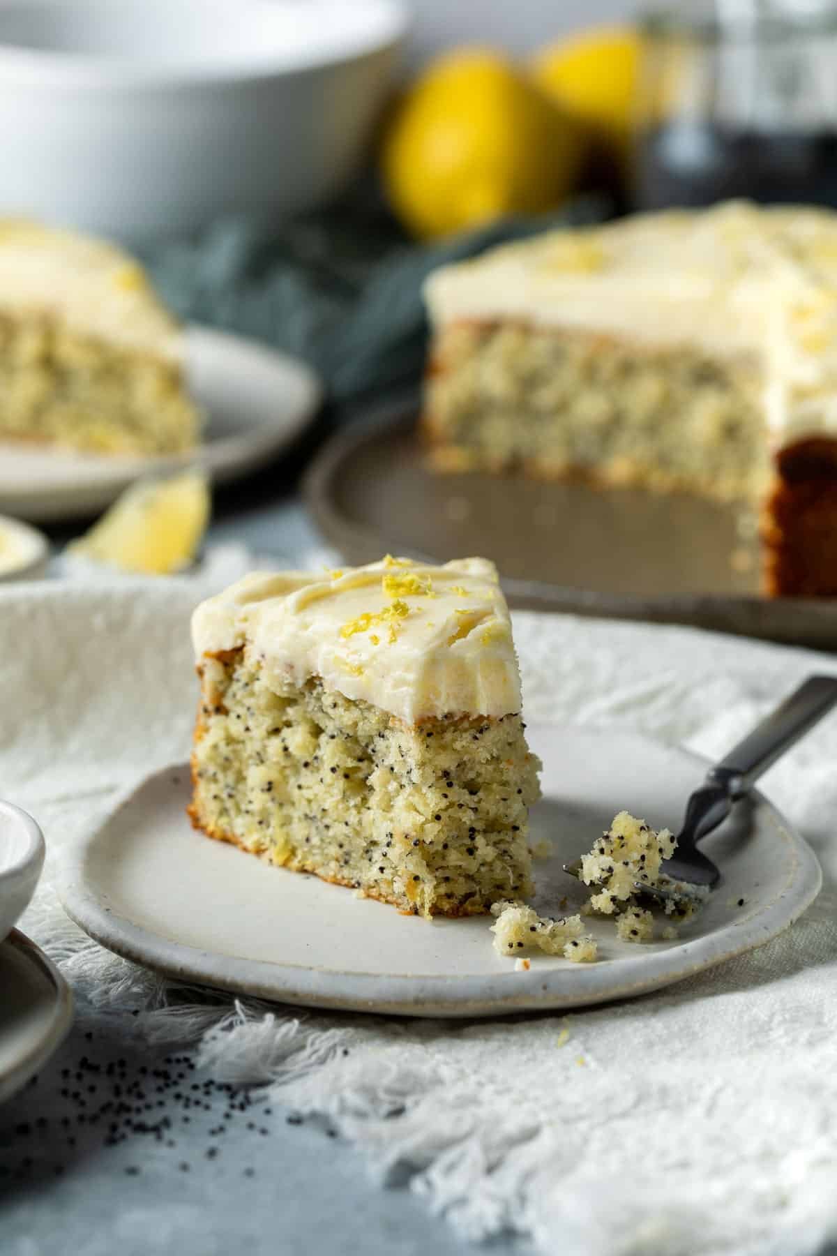 a slice of lemon poppyseed cake on a plate with a fork.
