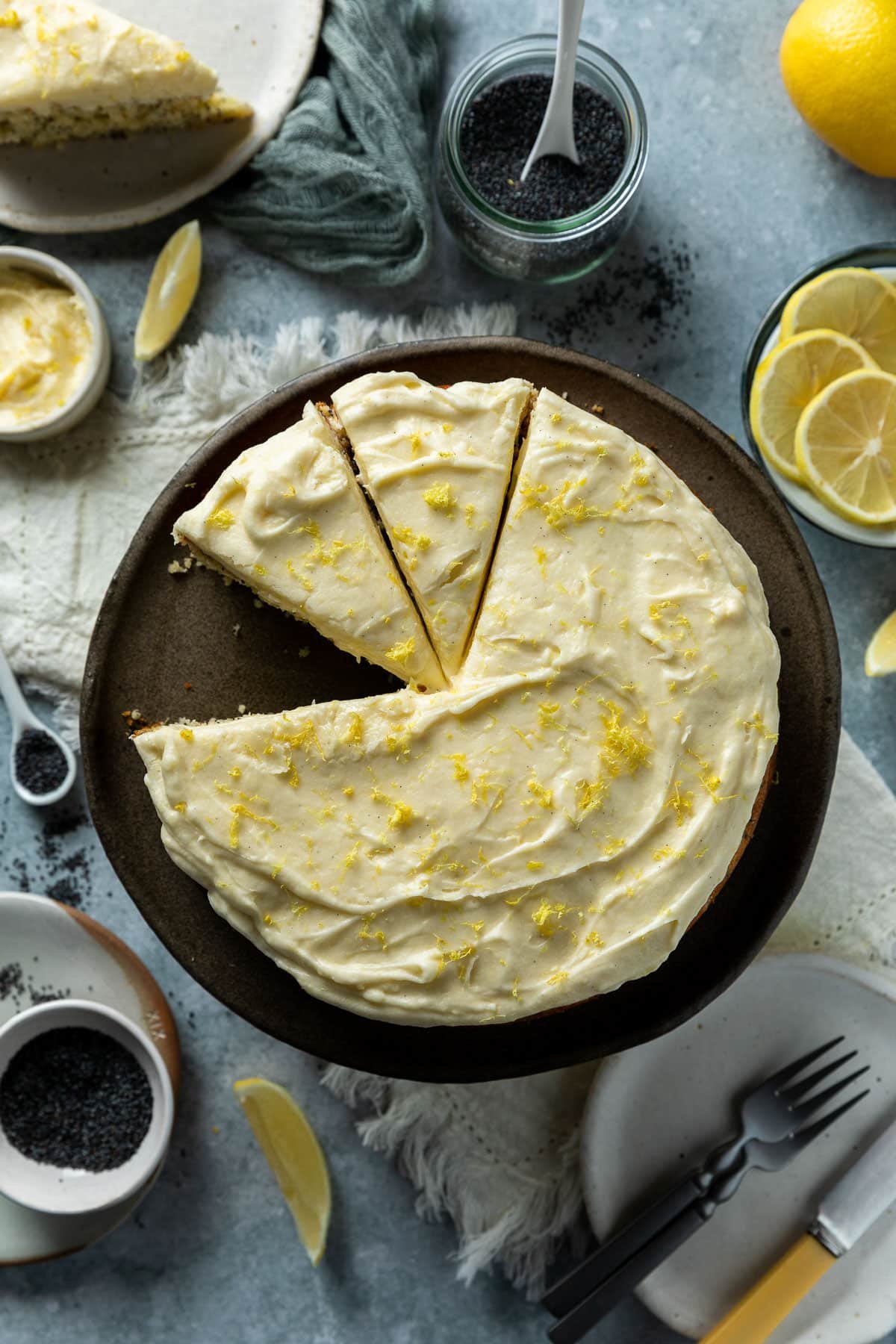 a cake on a plate, topped with frosting and lemon zest. 
