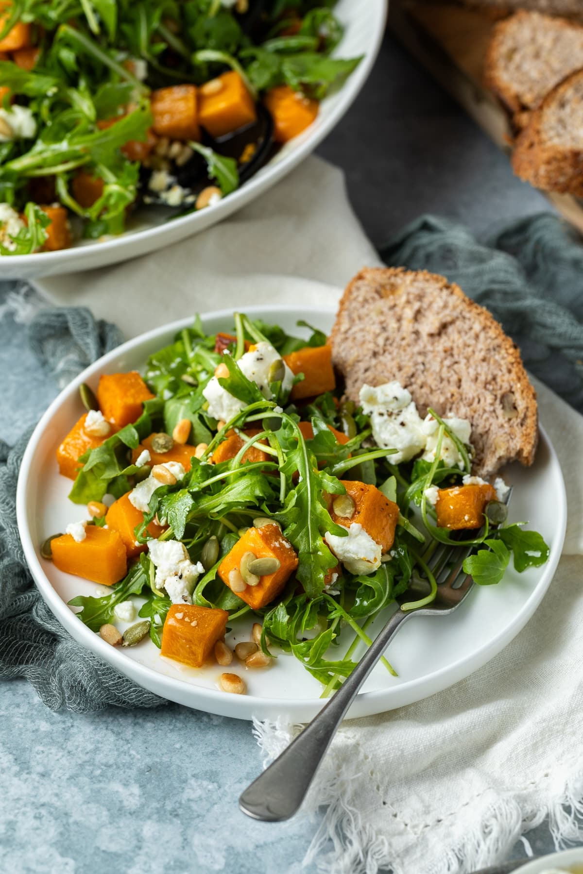 a plate with roast pumpkin salad and bread.