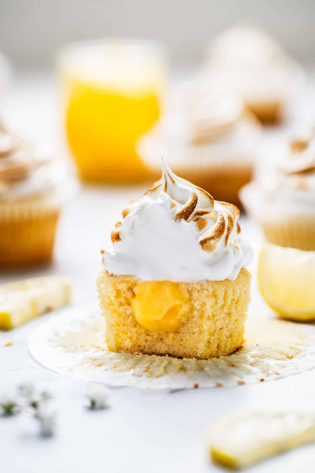 a cupcake, cut in half. It is filled with lemon curd and topped with meringue.