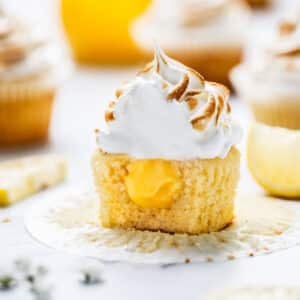 a cupcake, cut in half. It is filled with lemon curd and topped with meringue.