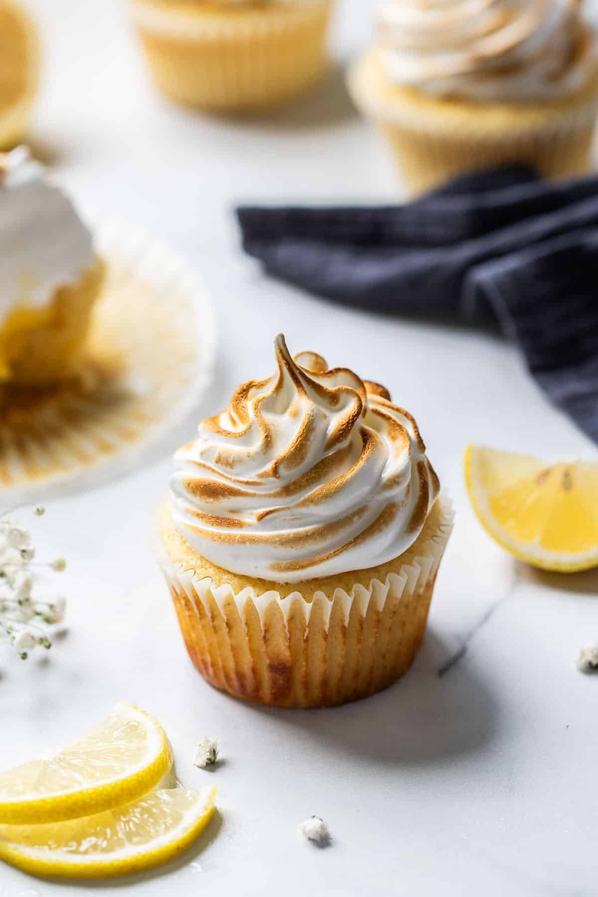 a cupcake on a table, with lemon slices.