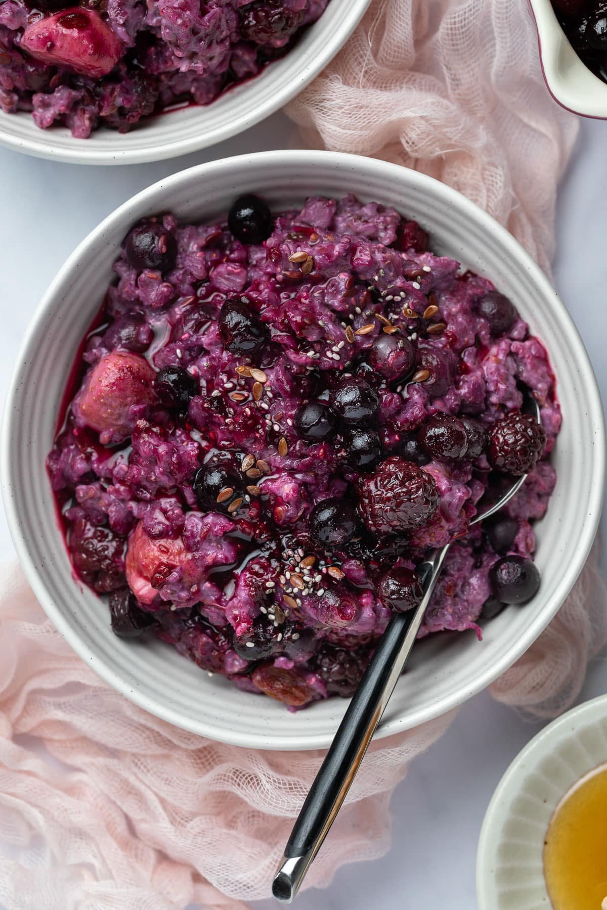 porridge in a bowl, topped with berries.