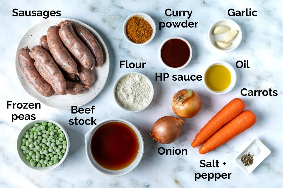 all ingredients for keens curried sausages laid out on a table.