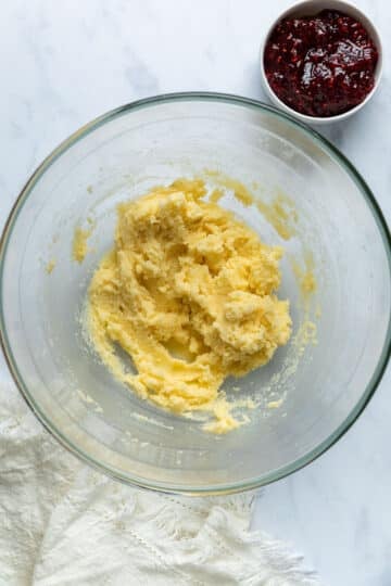 a glass bowl with creamed butter and sugar mixture.