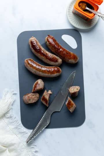 sausages being sliced on a cutting board.