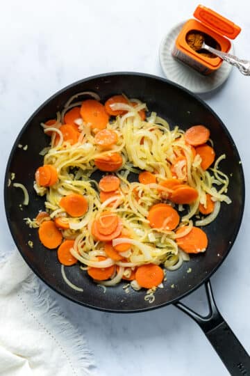 sauteed onion and carrot in a pan.