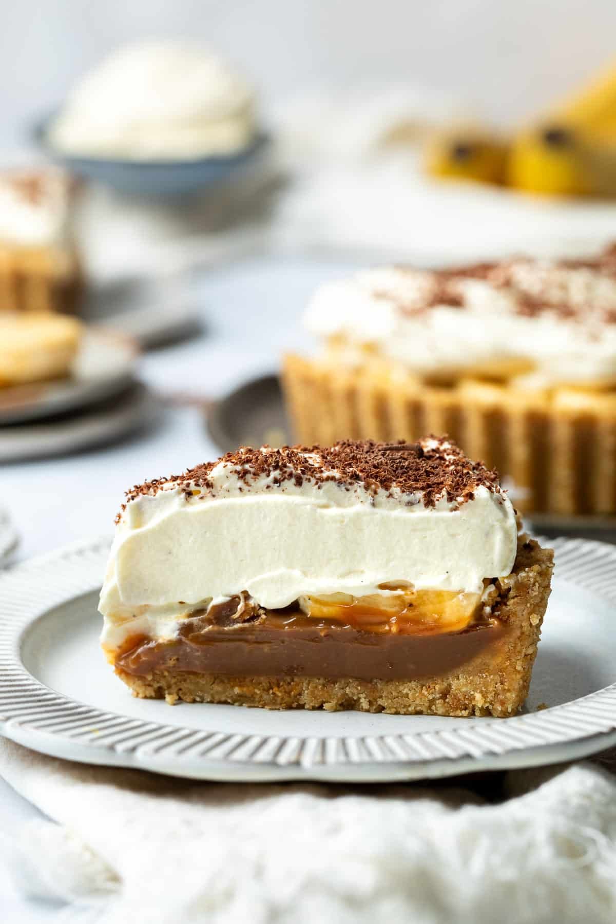 a slice of banoffee pie topped with whipped cream on a plate.