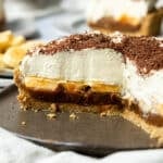 banoffee pie on a plate, sliced in half to show its layers.