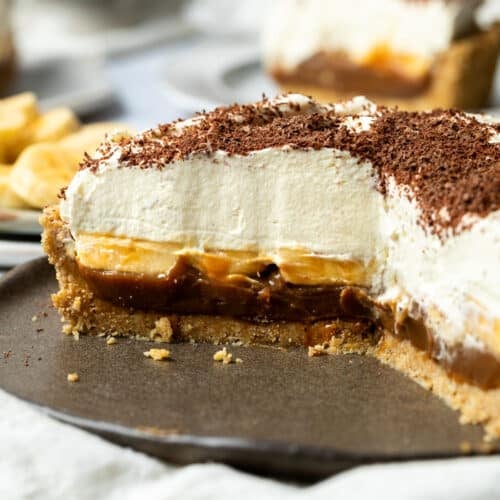 banoffee pie on a plate, sliced in half to show its layers.
