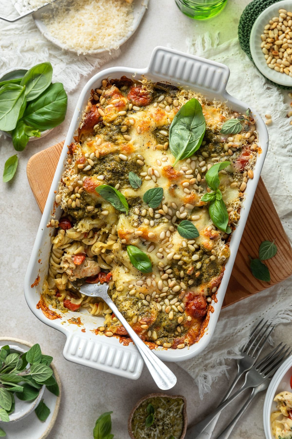 pesto pasta bake in a large baking dish on a table.