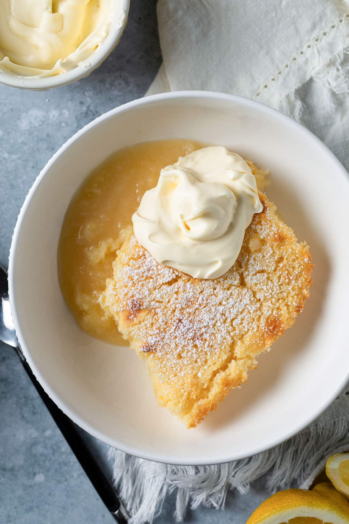 a bowl of lemon delicious pudding, topped with cream.
