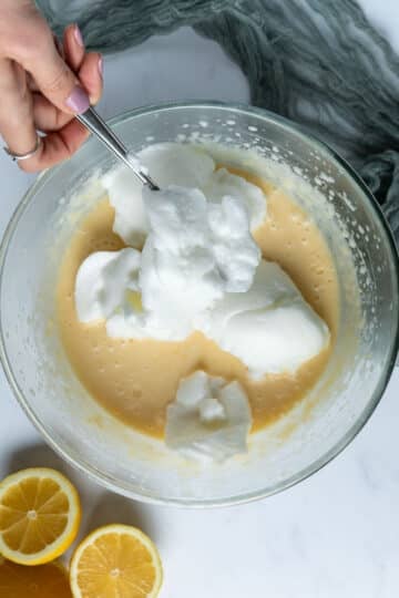 fluffy egg whites being folded into pudding batter.
