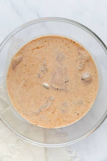 chicken soaking in buttermilk mixture.