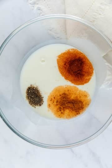buttermilk and chicken-coating spices in a bowl.