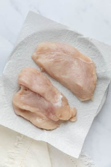 sliced chicken breast on a plate lined with paper towel.