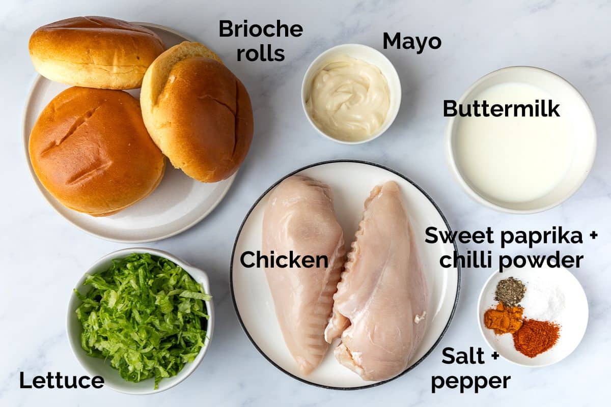 crispy chicken burgers ingredients laid out on a table.