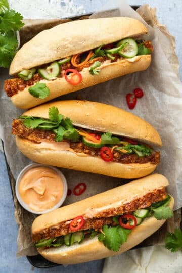 a tray of banh mi (pork rolls) arranged on a tray with a dish of chilli mayo.