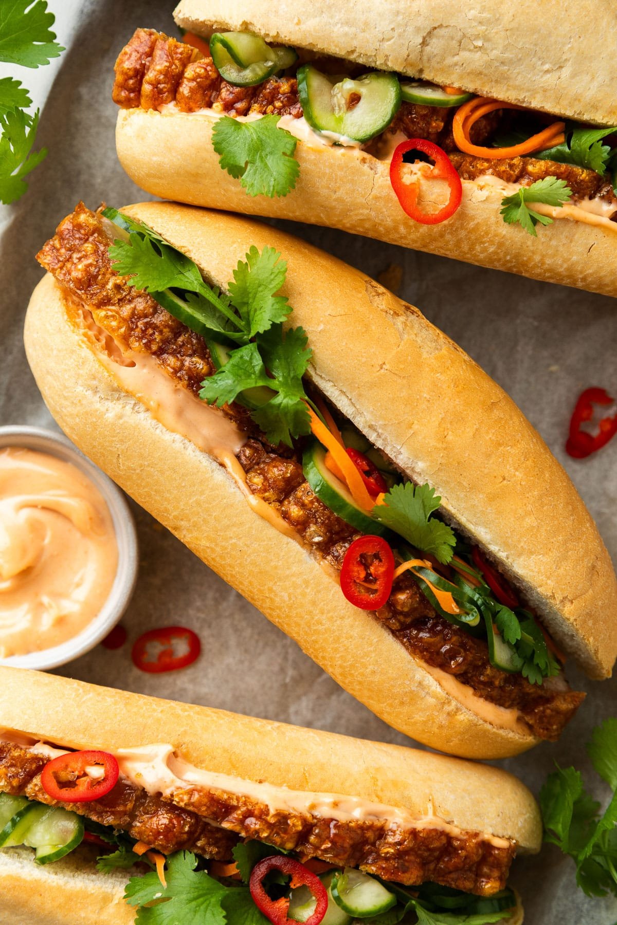 pork rolls on a tray, filled with pickled vegetables, coriander and chilli.