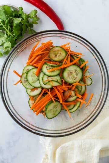 sliced cucumber and carrot in a glass bowl. 