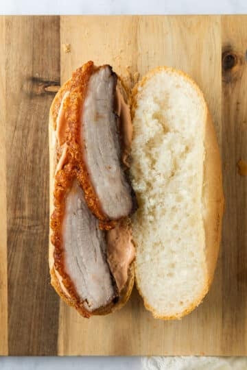 sliced pork belly arranged on a baguette.