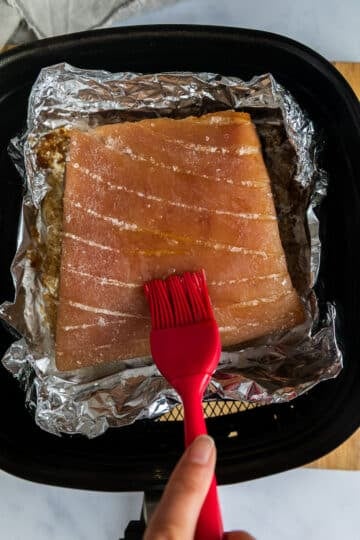 pork belly skin being brushed with oil.