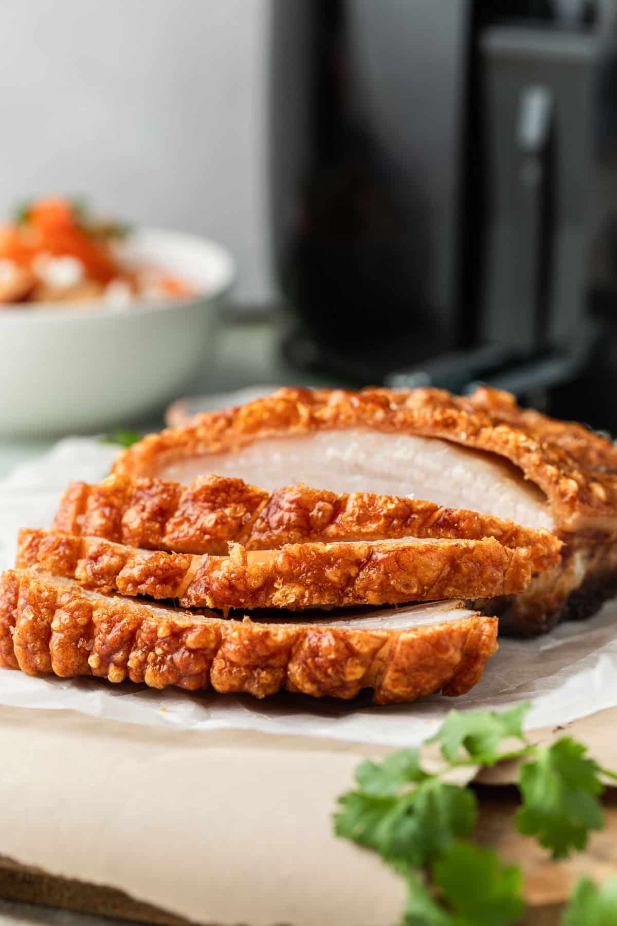 pork belly on a table. It has been sliced and is topped with crispy crackle.