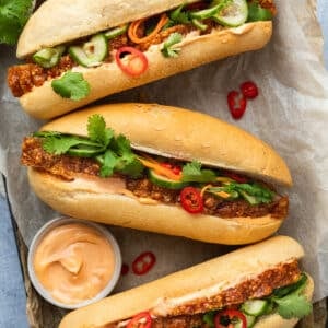 Banh mi (pork rolls) on a tray with a dish of chilli mayo.