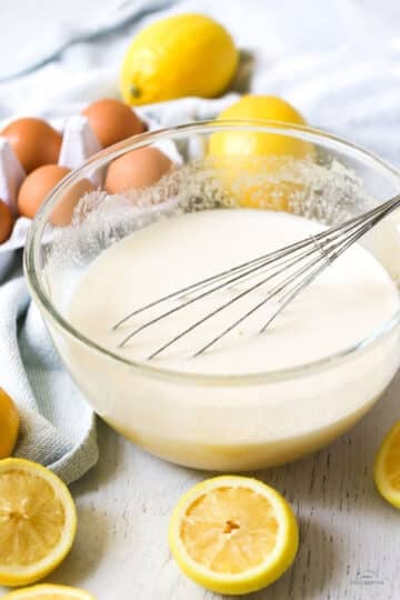 lemon curd mixture in a mixing bowl with a whisk.