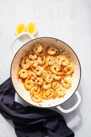 a pan with cooked prawns in oil.