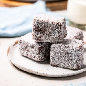 a plate of lamingtons coated in coconut.