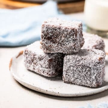 a plate of lamingtons coated in coconut.