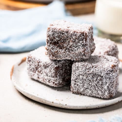 a plate of lamingtons coated in coconut.