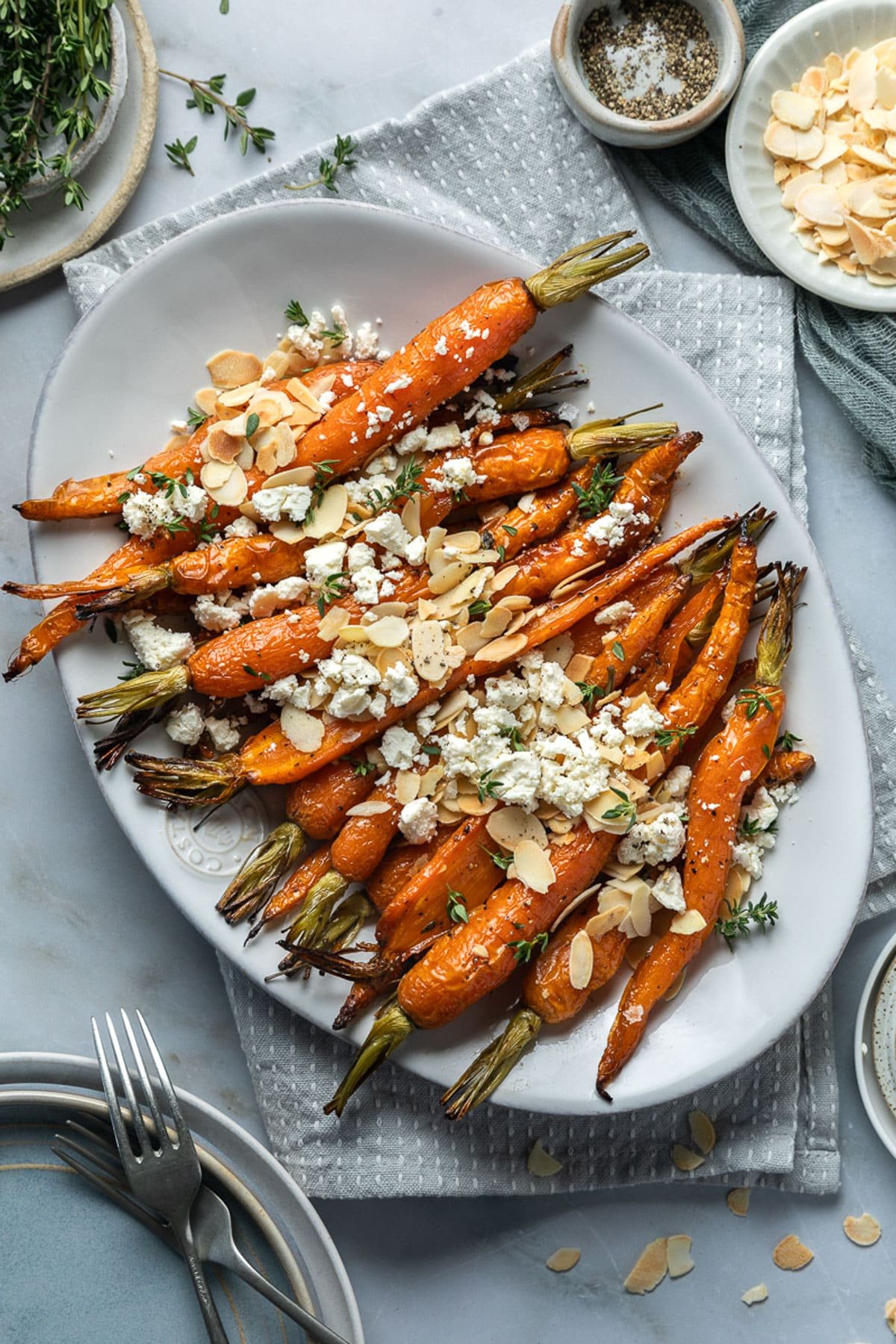 a plate of roasted Dutch carrots topped with almonds, herbs and feta.