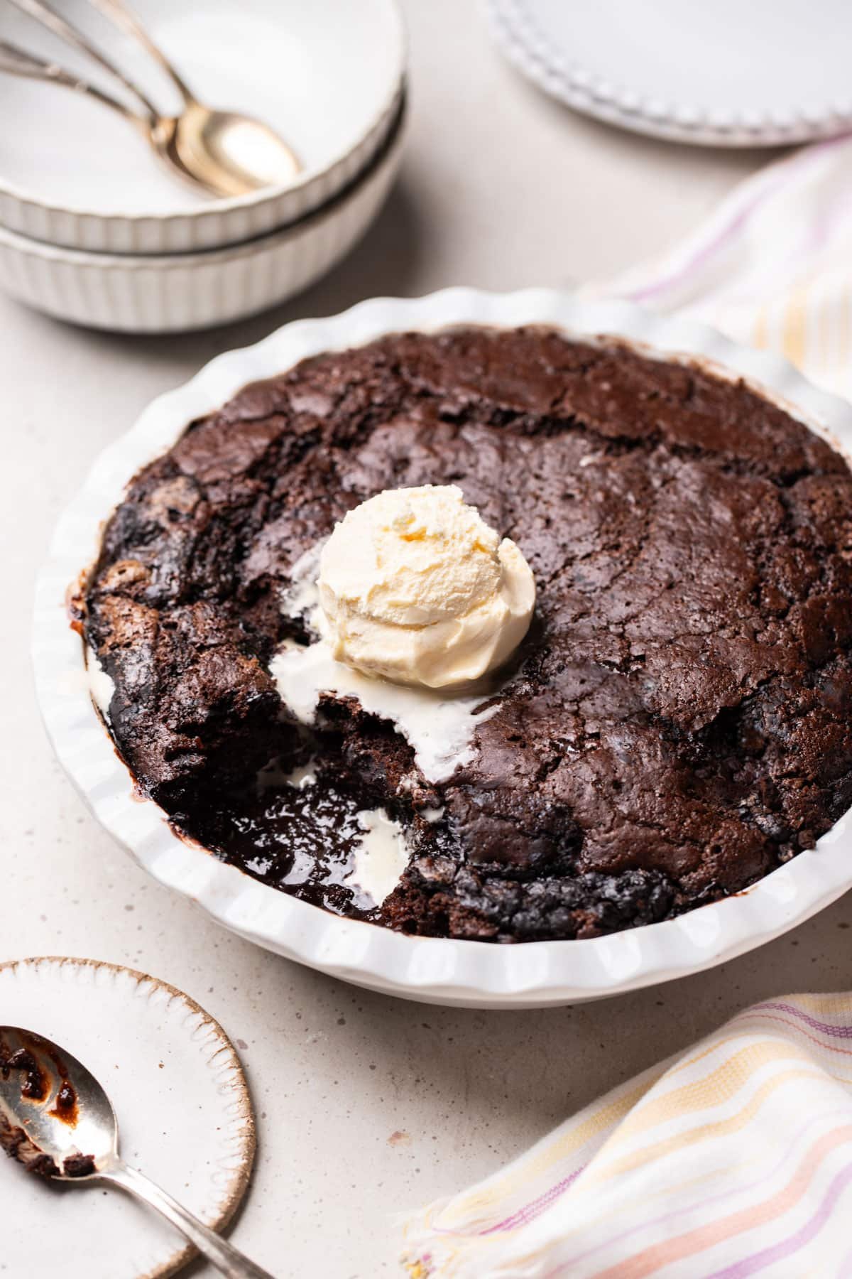 a dish with chocolate self saucing pudding and a scoop of ice cream on top.